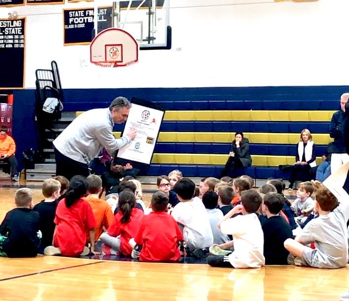 Coach presenting award to kids